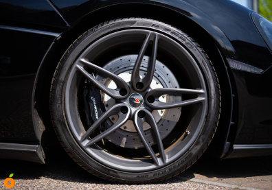 close ups of wheels on a Mercedes-AMG and a McLaren sports car